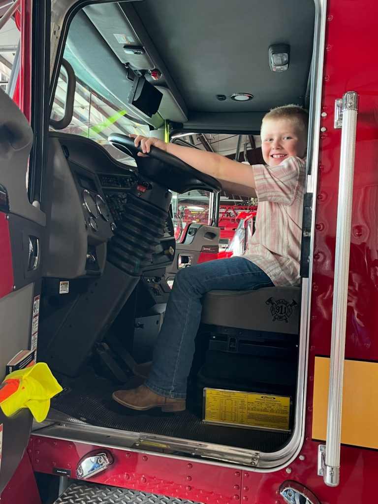 Noah Noland sits behind the wheel of a fire engine. He visited the firehouse to make a donation to the Safe Haven Baby Box. Photo Credit: Submitted photo